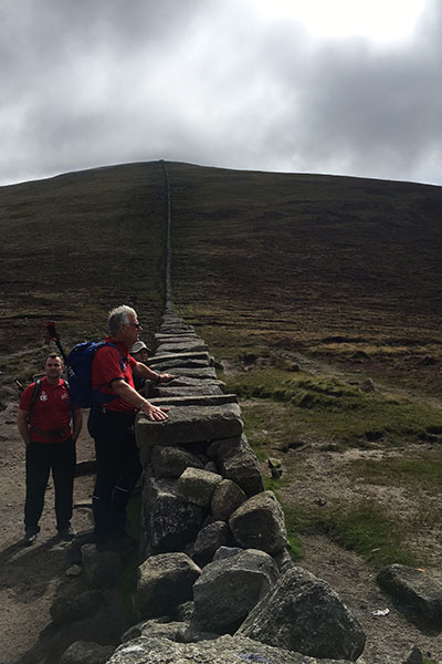 Robert Louden looking over the Mourne Wall with the summit in the background