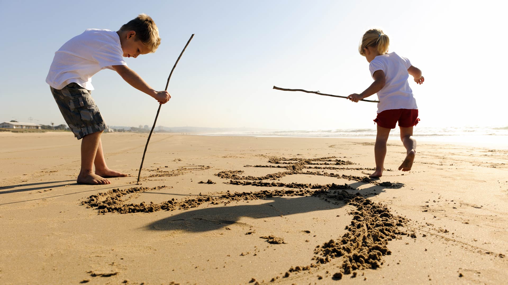 kids drawing in the sand