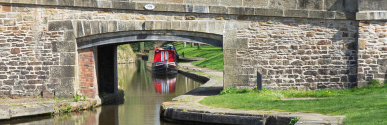 Canal boat passing under bridge in Llangollen Wharf, Wales