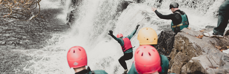 People coasteering and cliff jumping