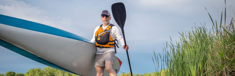 Male paddleboarder wearing PFD