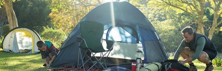 father and son pitching a tent