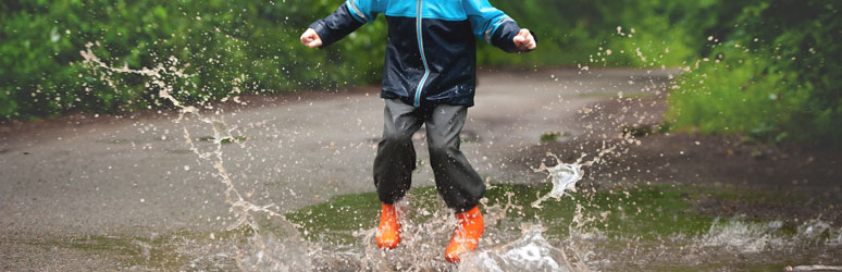 Child jumping in puddle