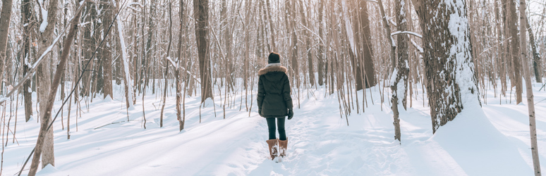 Woman walking through the snowy woods