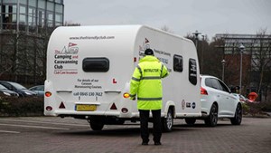 man in high vis jacket instructing caravan