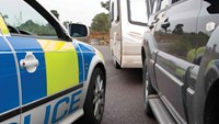 Police car parked up next to large car