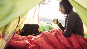 Couple in sleeping bags inside tent
