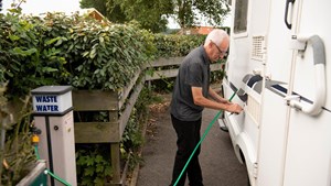 Man filling up water tank on motorhome