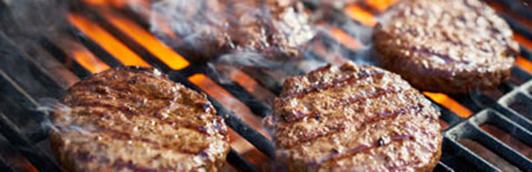 four burgers being cooked