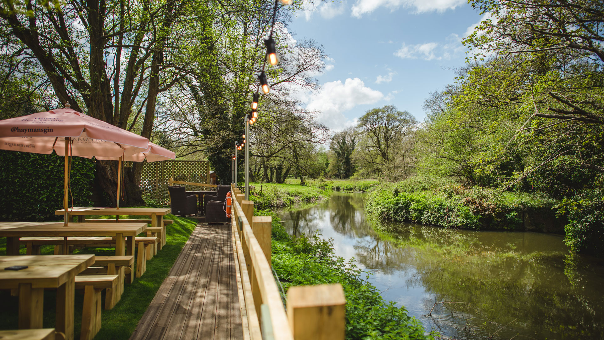 Tables along the river at The Stag on the River Pub in Surrey