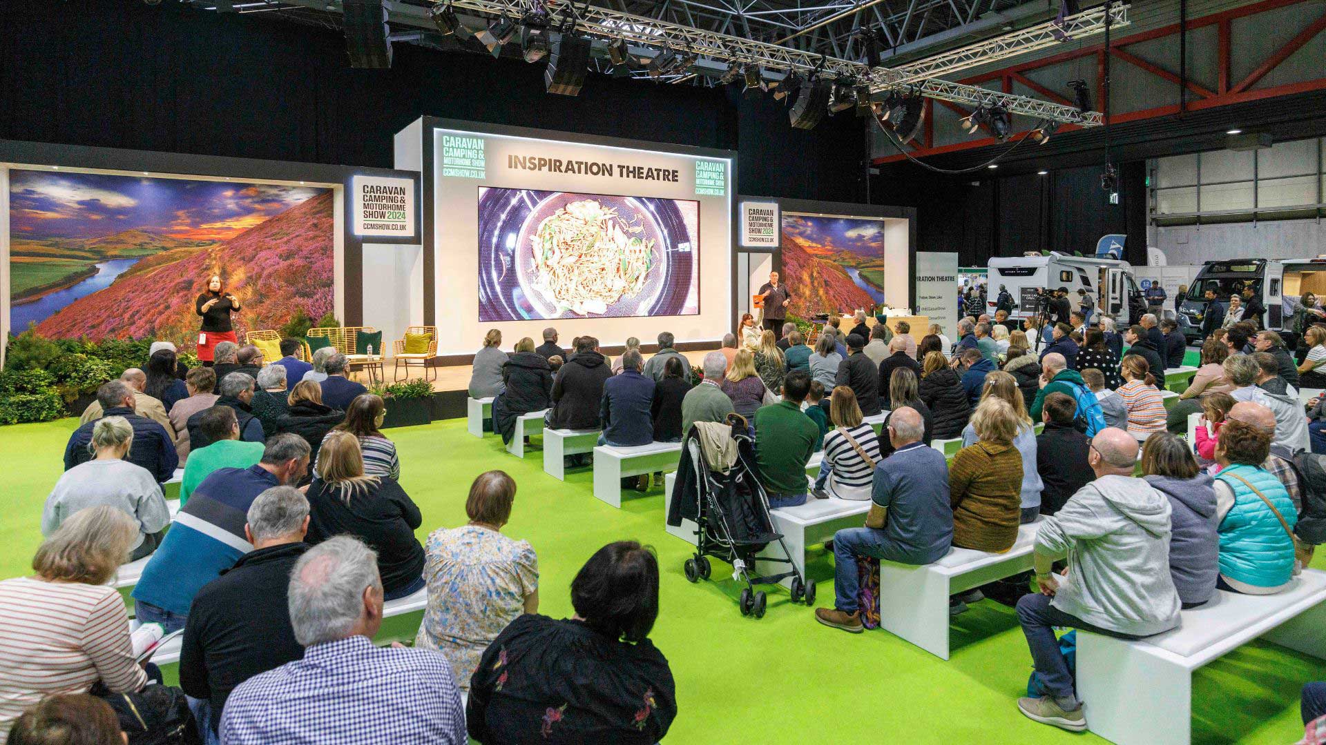 Visitors sit listening to a speaker at the Caravan Camping and Motorhome Show