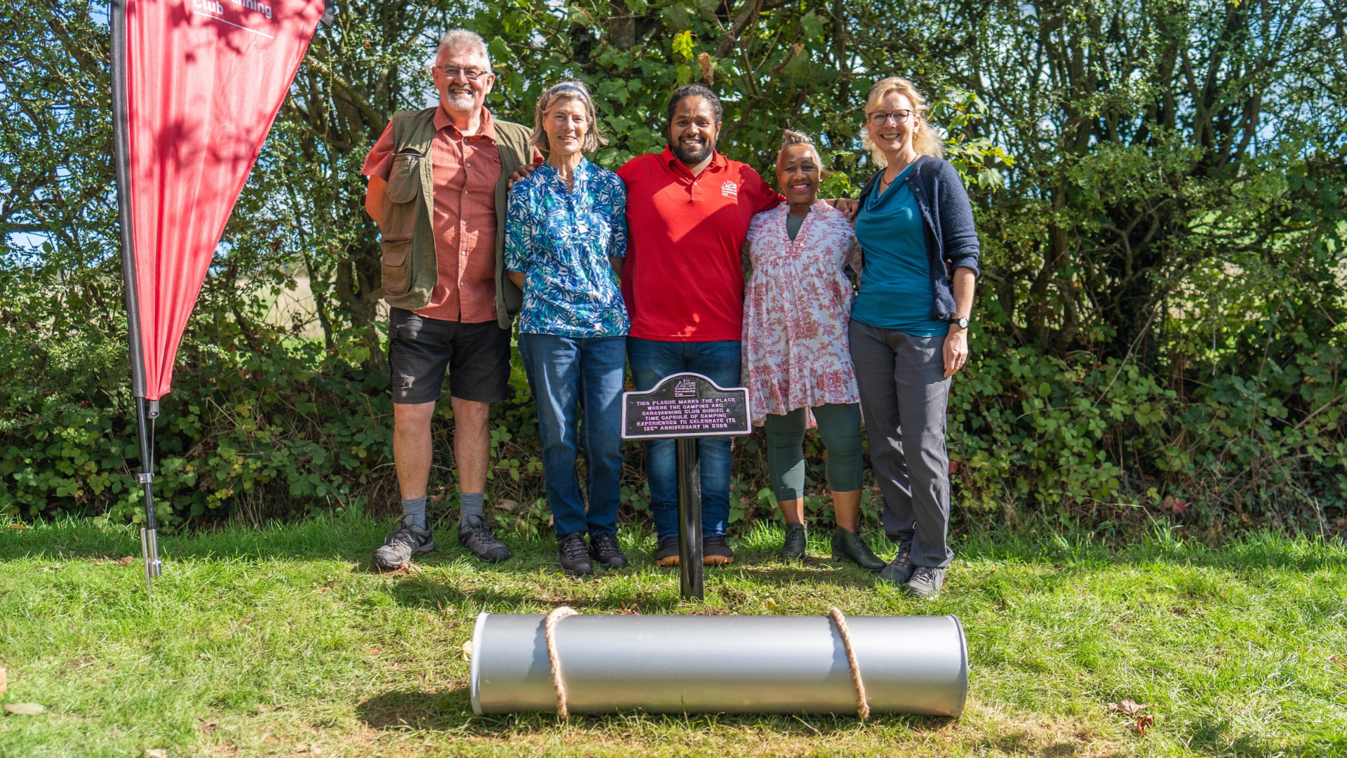 Hamza Yassin and prize winners standing behind the time capsule before its burial.