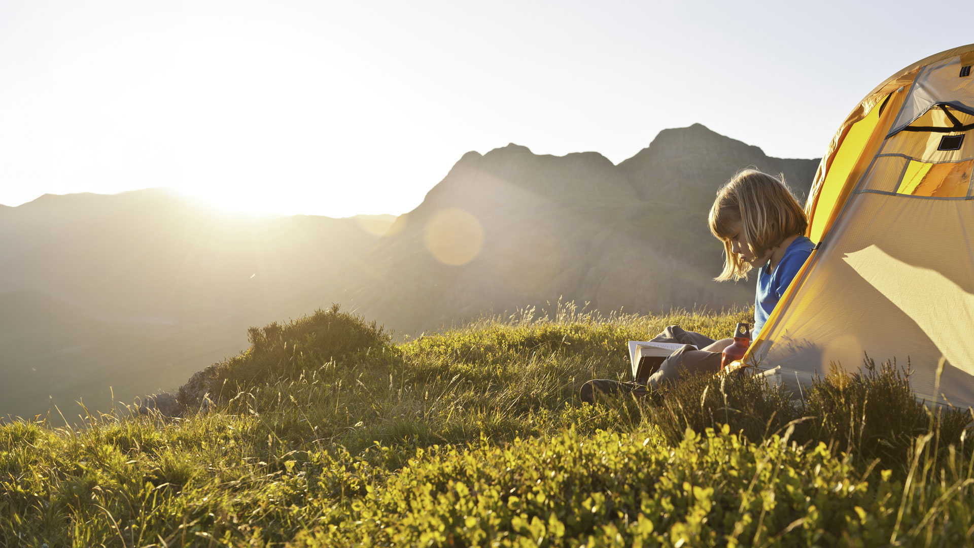 Girl reading book in tent