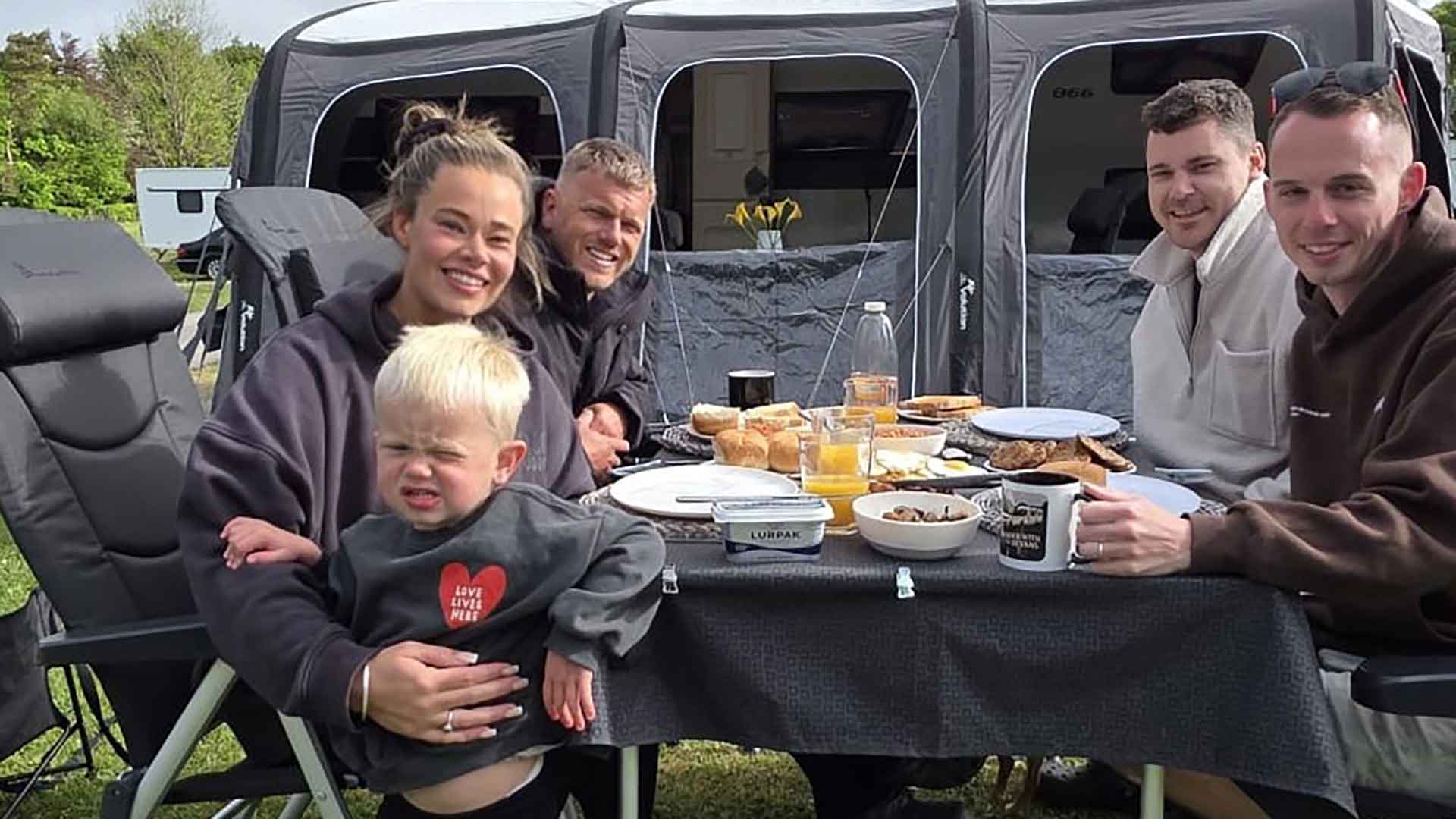 Rebecca Humphrey sits with friends on a campsite enjoying a meal and drinks