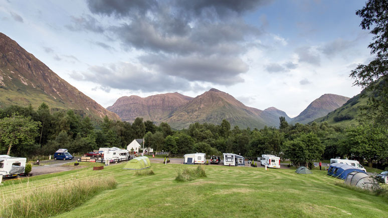 Caravans, tents and motorhomes pitched on Glencoe campsites in Scotland.