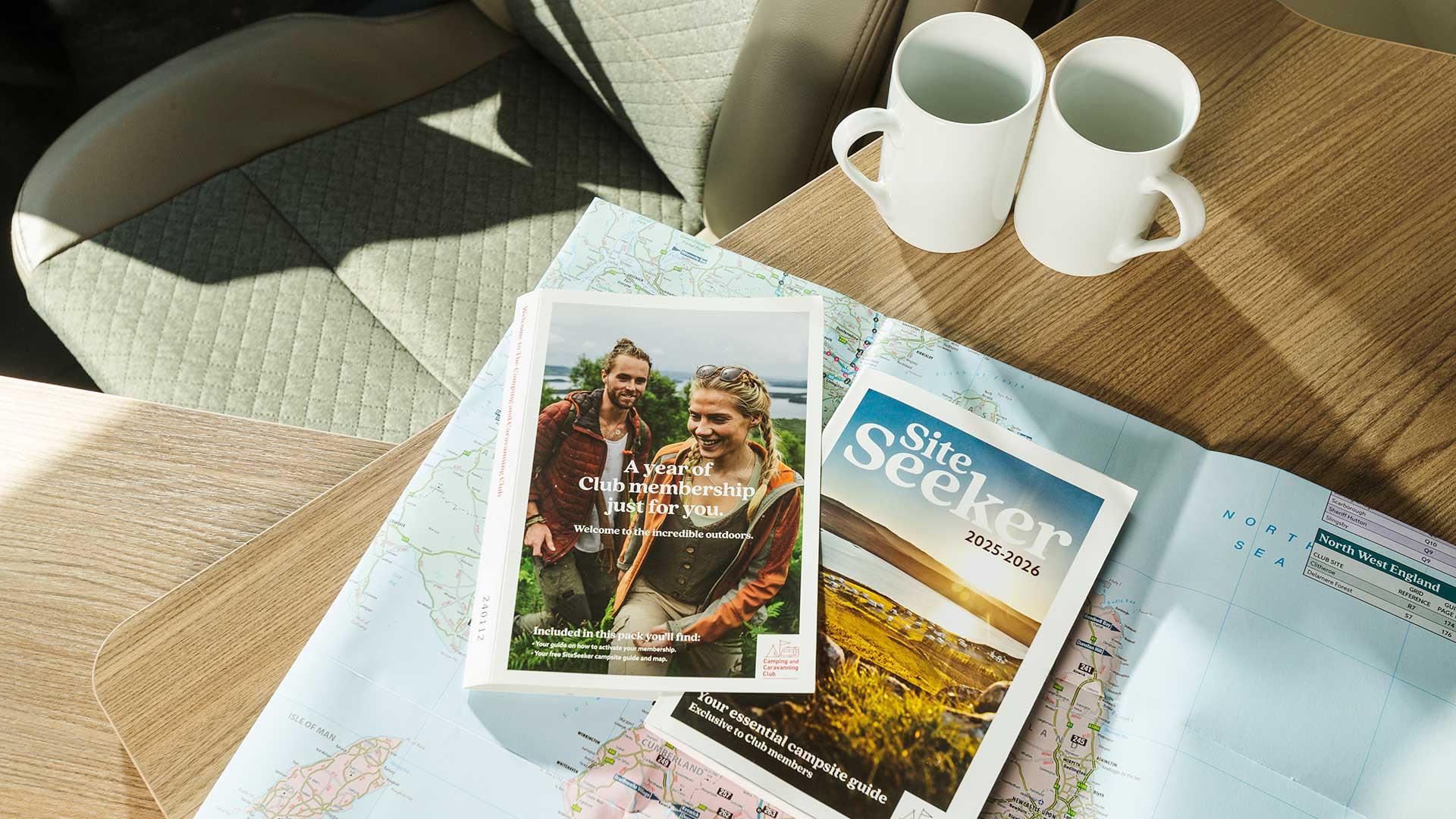 Coffee table with a map and magazines, two white coffee cups sit alongside.