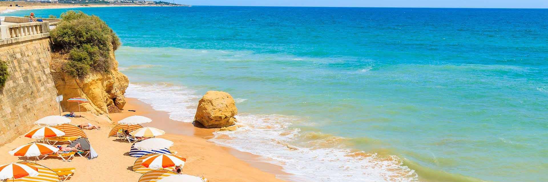 Sunny beach with orange umbrellas and blue sea in view